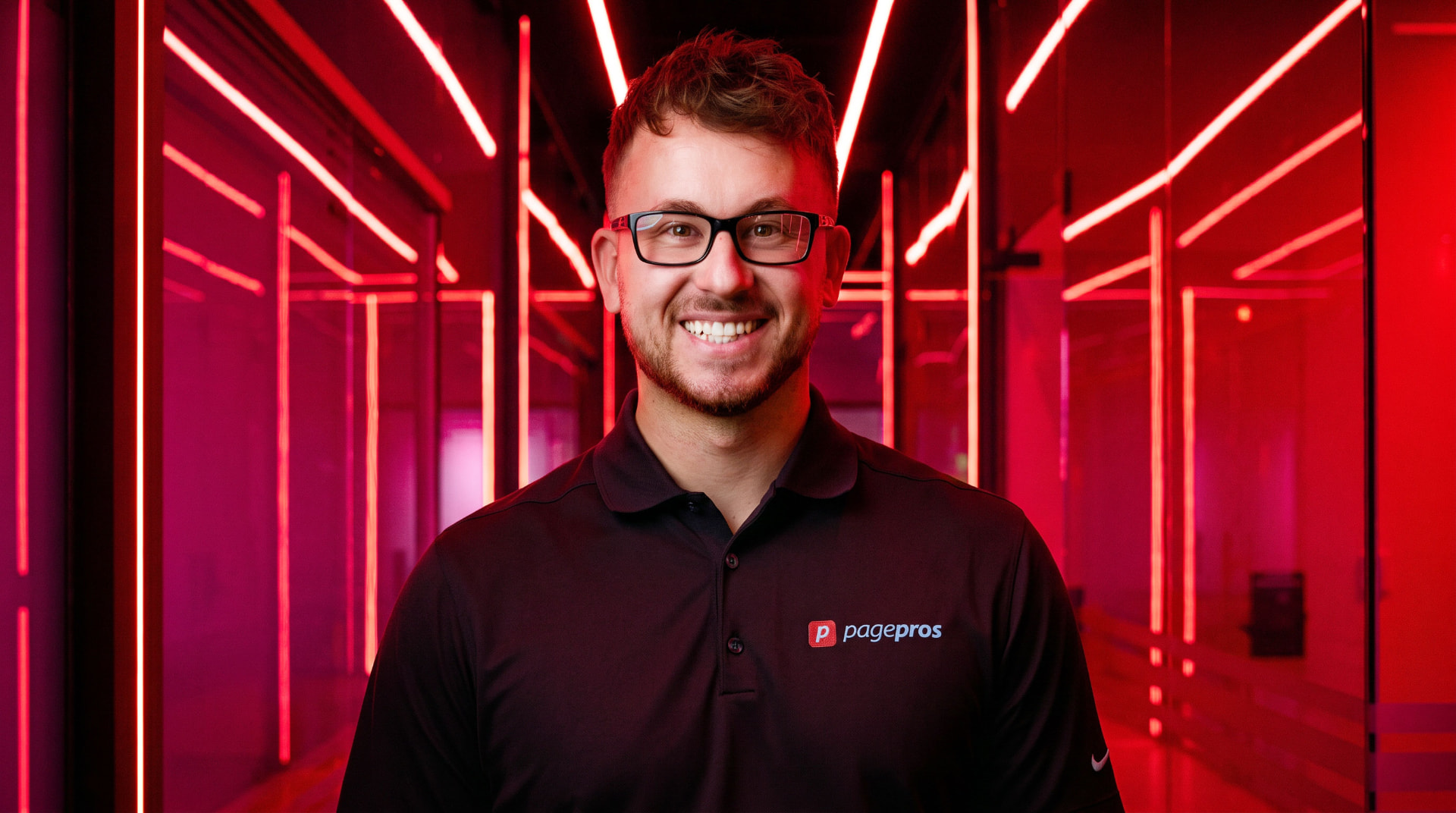 Jesse Galati, CEO and Co-Founder of Page Pros, in a red neon-lit corridor